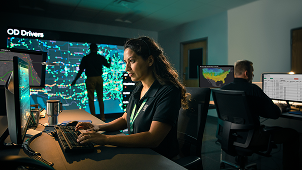 Command Center_Female employee typing at OD computer with Drivers Screen in background