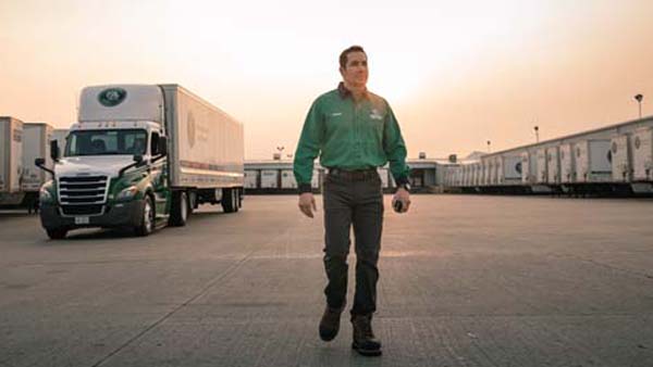 Driver_WalkingToCamera_Front_TractorBackground_Yard_Dusk_600x338.jpg