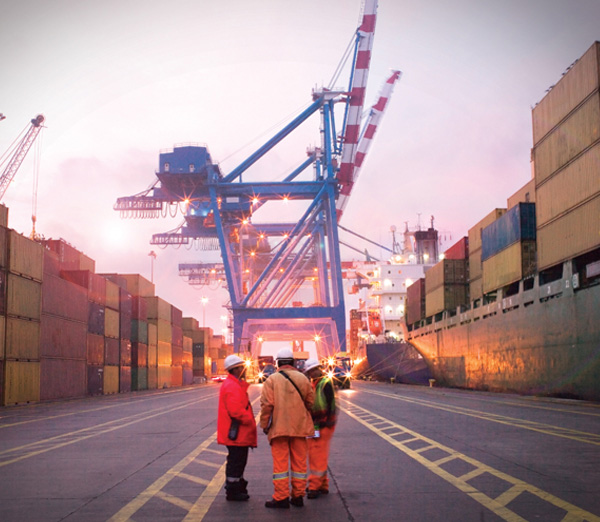 Shipyard Workers by cranes at dusk