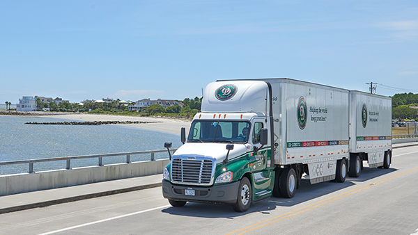 OD truck driving over bridge of water.