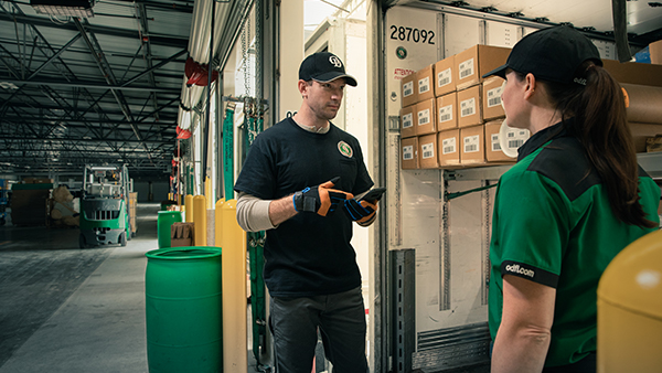 Dock worker with handheld talking with driver